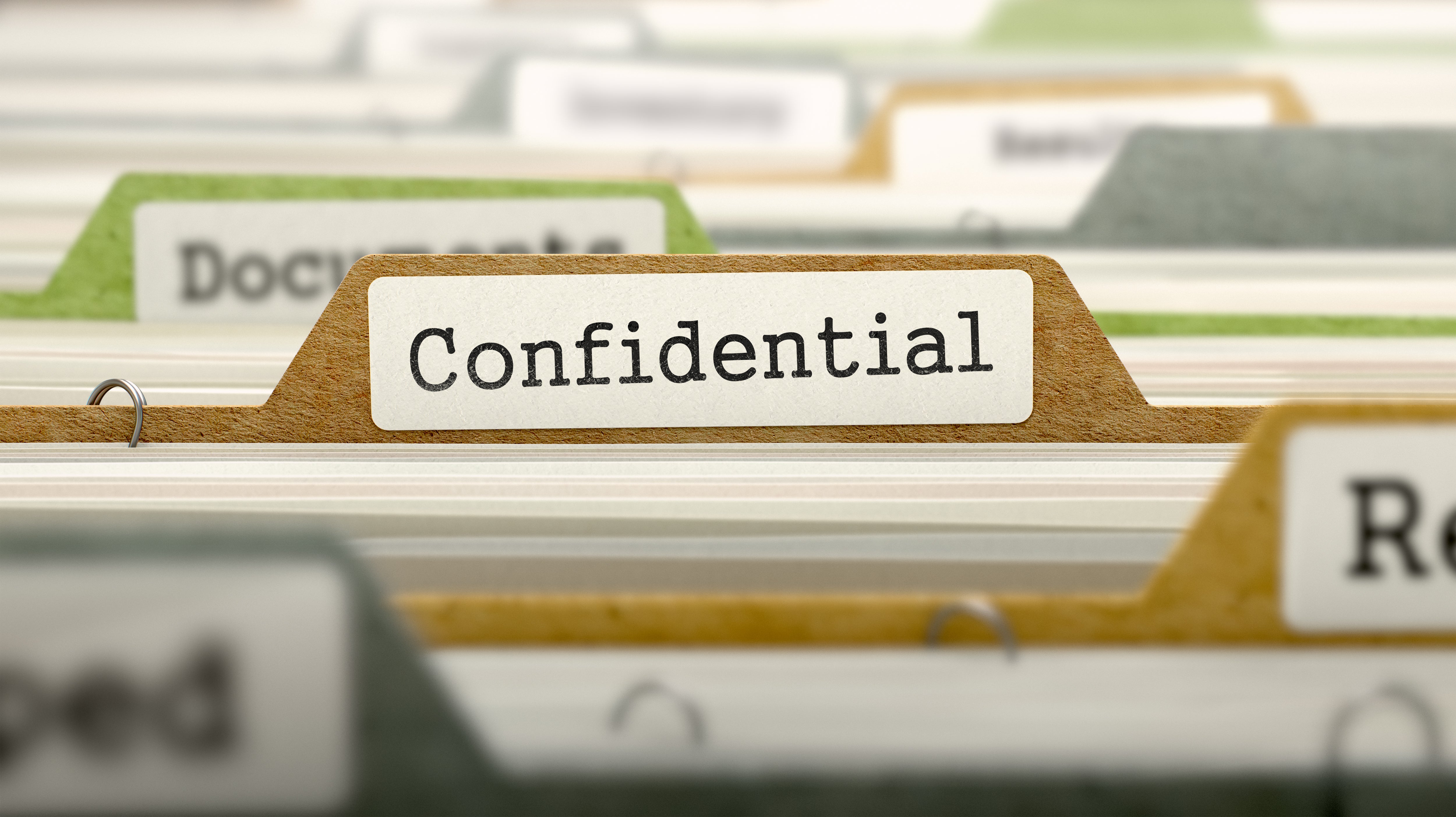 paper files with one in focus with a tabl saying "confidential"