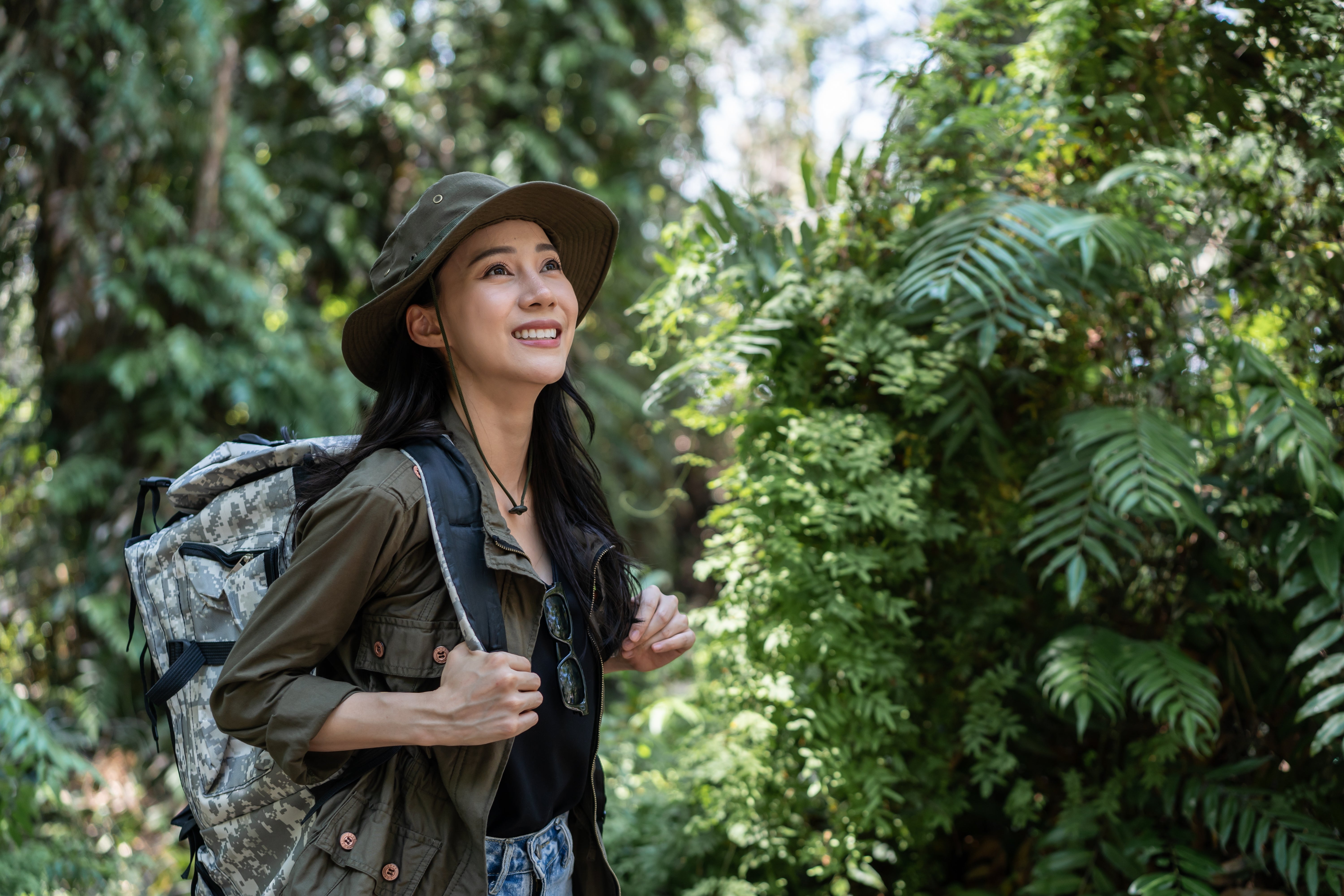 Woman smiling in nature as she hikes in forest.