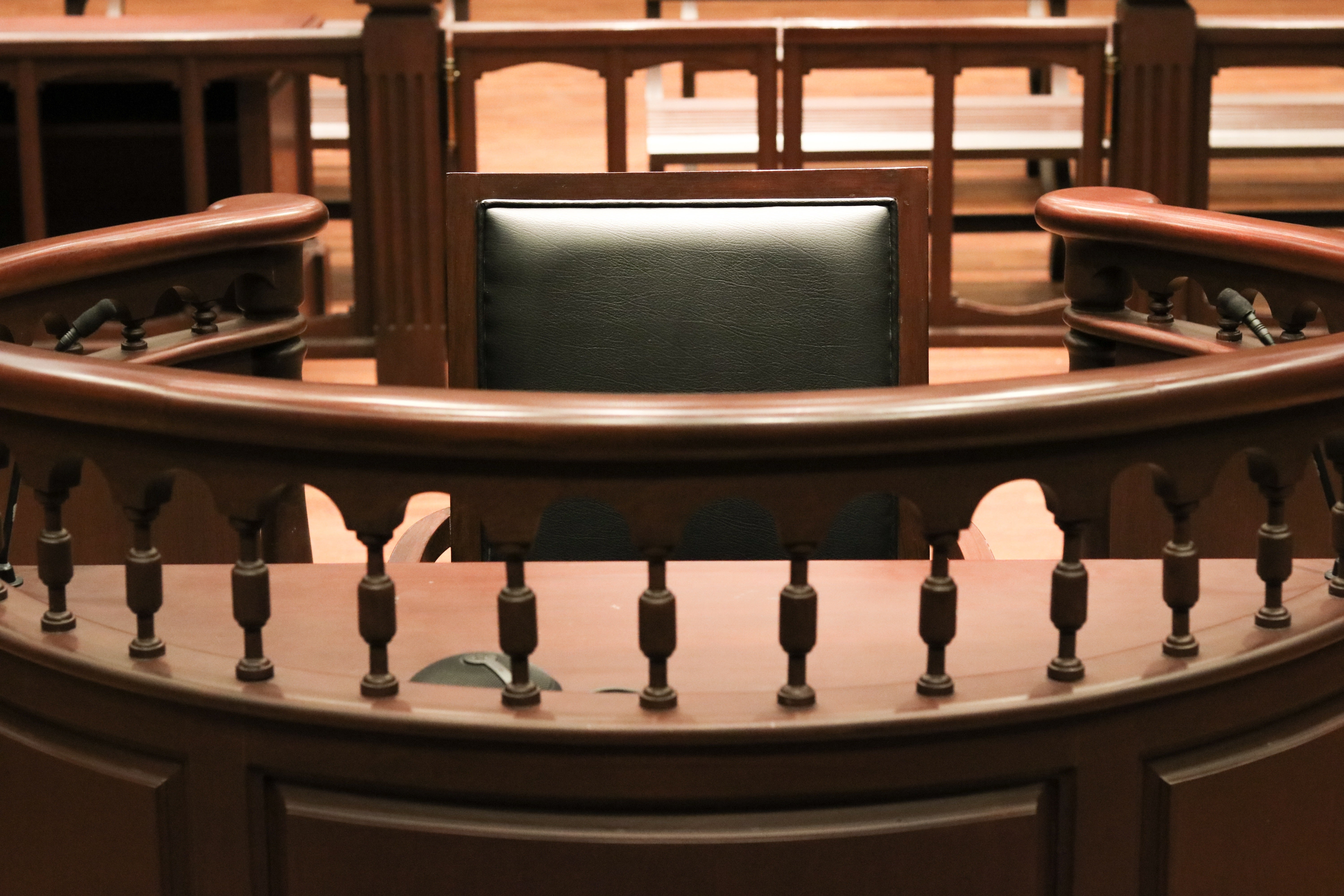 A witness stand with a black seat in the court room.