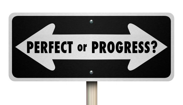 sign says "perfect" going toward left and "progress" going toward right with question mark at end