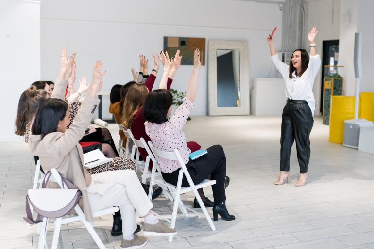 A group of participants raising their hands, being engaging in a training session. 