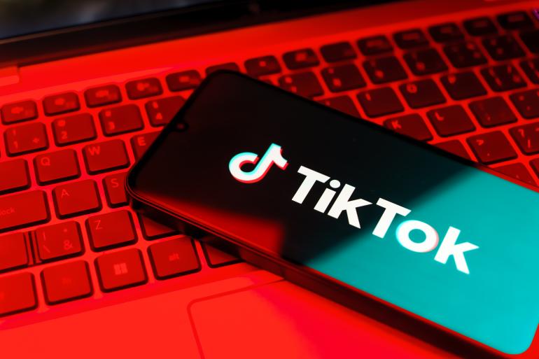 Image of TikTok on a phone with red background