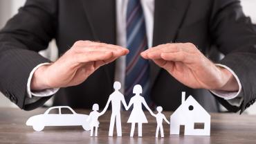 a man protecting outlines of a car, family, and a house with his hands