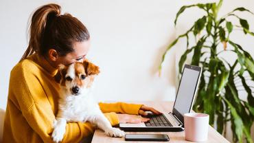 woman with dog sitting at the computer