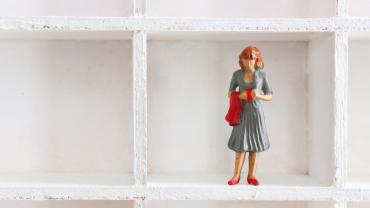 Doll figurine alone on a shelf