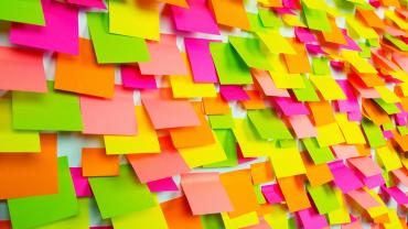 Dozens of bright, colorful sticky notes covering a whiteboard.