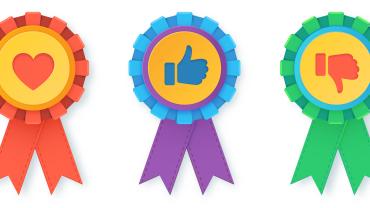 three award ribbons, one red with a heart, one blue and purple with a thumbs up, one green with a thumbs down