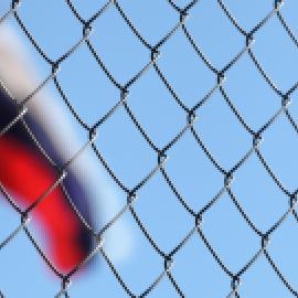 Russia flag behind chain link fence