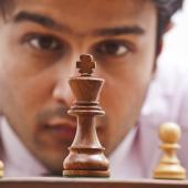 man staring at chess pieces