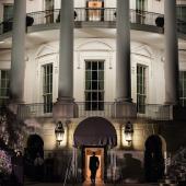 White House lit at night and man walking into the southside entryway