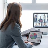 office workers gathered around a screen hosting a virtual meeting