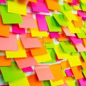 Dozens of bright, colorful sticky notes covering a whiteboard.